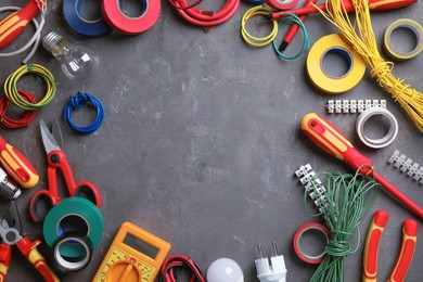 Photo of Frame of electrician's tools and accessories on grey background, flat lay. Space for text
