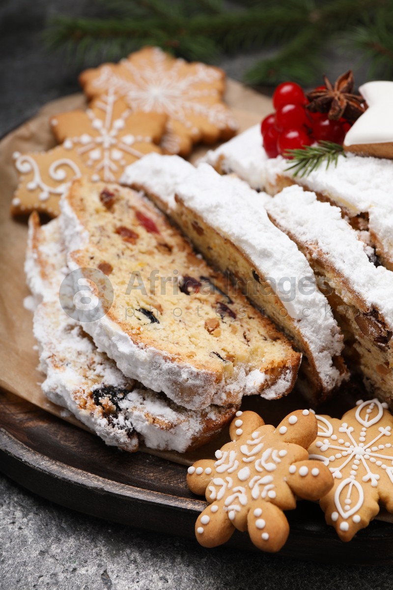 Traditional Christmas Stollen with icing sugar on grey table, closeup