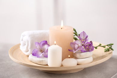 Beautiful composition with spa stones and burning candles on grey table