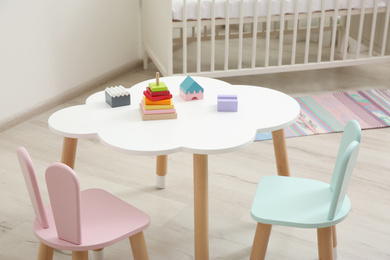 Little table and chairs with bunny ears in baby room. Interior design