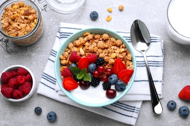 Photo of Flat lay composition with tasty granola and berries on light grey table. Healthy meal