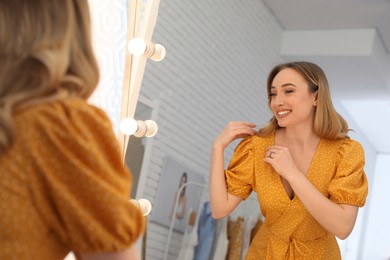Woman trying on stylish dress in showroom