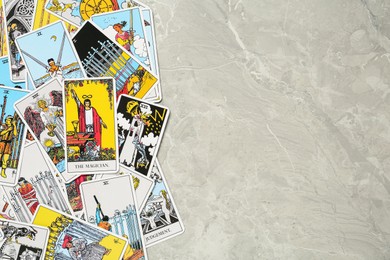 Tarot cards on light grey marble table, top view. Space for text