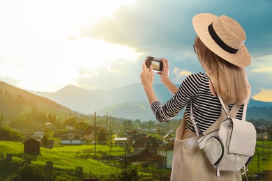 Traveler with backpack taking photo during summer vacation trip