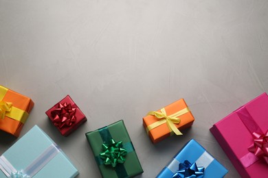 Many colorful gift boxes on light grey table, flat lay. Space for text