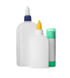 Different bottles and stick of glue on white background