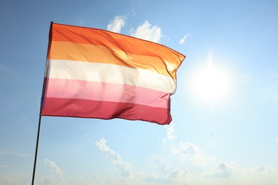 Photo of Bright lesbian flag fluttering against blue sky