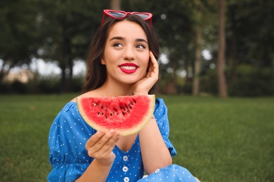 Beautiful young woman with watermelon in park on sunny day
