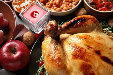 Photo of Traditional Thanksgiving day feast with delicious cooked turkey and other seasonal dishes served on table, closeup