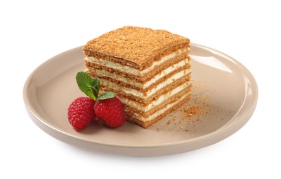Photo of Slice of delicious layered honey cake with mint and raspberries on white background