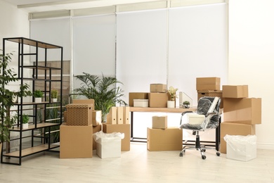 Cardboard boxes and packed chair in office. Moving day