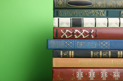 Stack of different hardcover books on green background