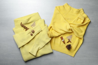 Photo of Yellow warm sweaters on light grey table, flat lay