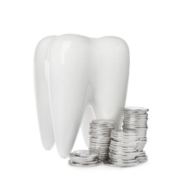 Ceramic model of tooth and coins on white background. Expensive treatment