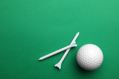 Golf ball and tees on color background, flat lay. Space for text