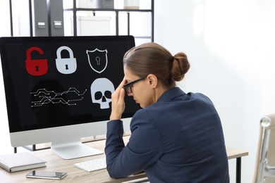 Office worker in front of computer with warning about virus attack on screen