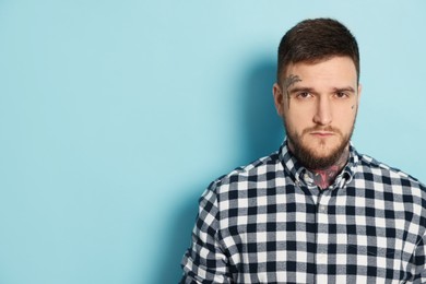 Photo of Portrait of handsome hipster man on light blue background. Space for text