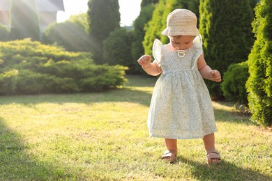 Cute little girl wearing stylish clothes outdoors on sunny day. Space for text