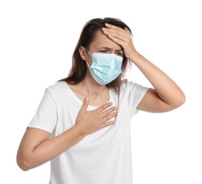 Mature woman with protective mask suffering from breathing problem on white background