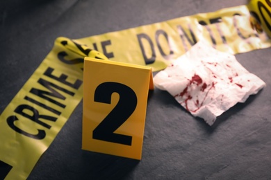 Photo of Crime scene marker on black slate table, closeup