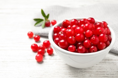 Tasty ripe cranberries on white wooden table, closeup. Space for text