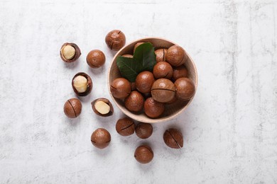 Photo of Delicious organic Macadamia nuts on white textured table, flat lay