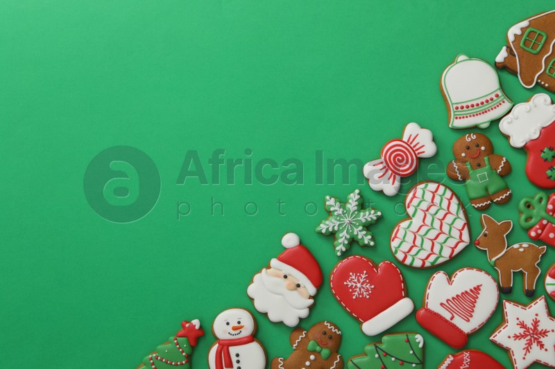 Different Christmas gingerbread cookies on green background, flat lay. Space for text