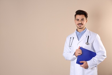 Young medical student with clipboard on color background. Space for text