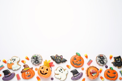 Tasty cookies and sweets for Halloween party on white table, flat lay. Space for text