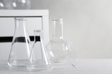 Set of laboratory glassware on white table indoors, space for text