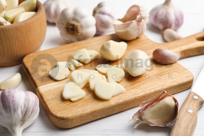 Fresh chopped garlic on wooden board, closeup. Organic product