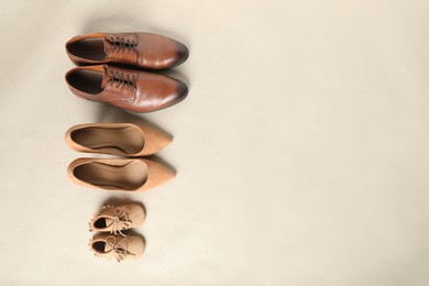Mother's, father's and child's shoes on beige background, flat lay with space for text. Family day