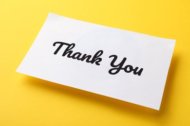 White paper note with phrase Thank You on yellow background