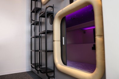 Capsule with purple light in modern pod hostel