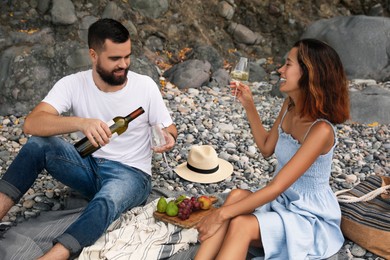 Happy young couple having picnic on beach