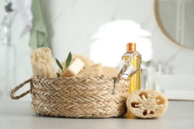 Photo of Natural loofah sponges and personal hygiene products on table indoors