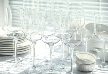 Set of empty wine glasses and dishware on table indoors