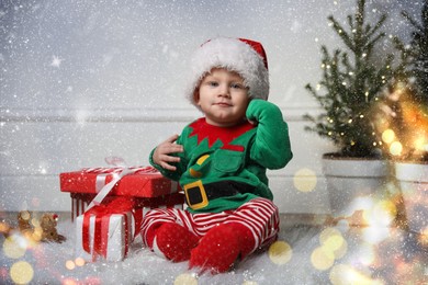 Baby wearing cute Christmas costume with gifts at home