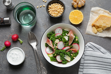 Tasty fresh kale salad on grey table, flat lay