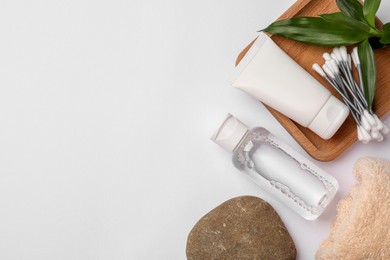 Flat lay composition with bottle of micellar cleansing water on white background, space for text