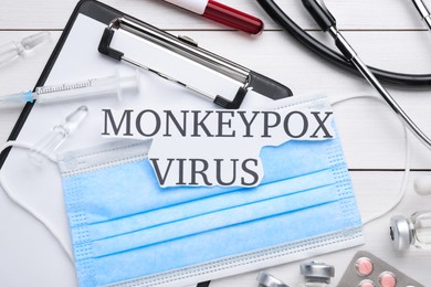 Photo of Flat lay composition with words Monkeypox Virus and medical supplies on white wooden table