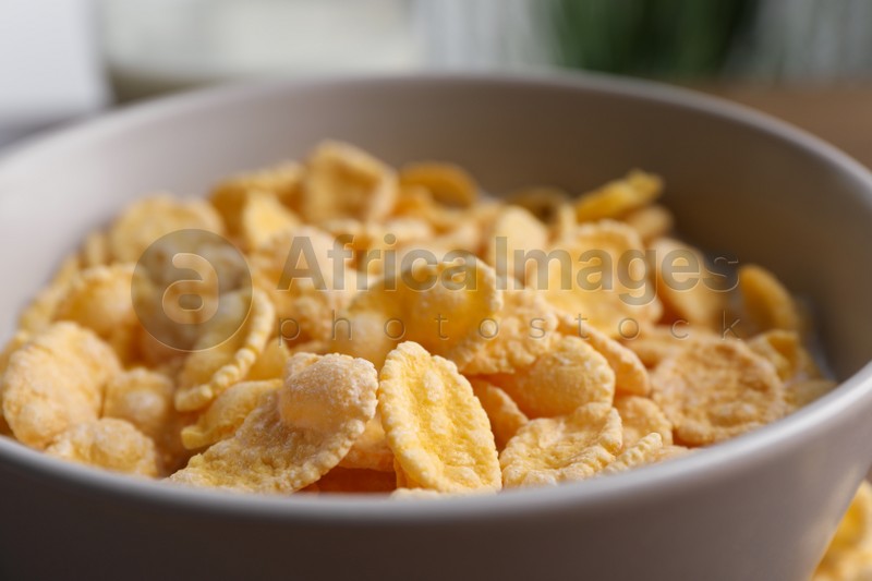 Tasty cornflakes with milk in bowl, closeup