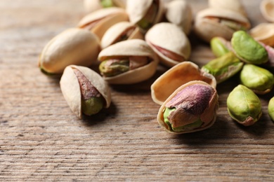 Organic pistachio nuts on wooden table, closeup