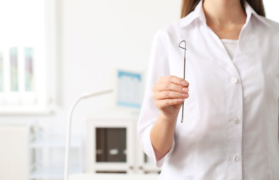 Speech therapist with logopedic probe in clinic, closeup. Space for text
