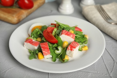 Delicious crab stick salad served on grey table