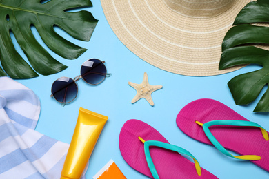 Flat lay composition with beach objects on light blue background