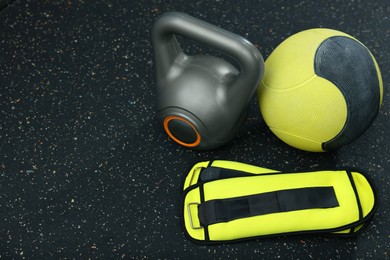 Yellow medicine ball, kettlebell and weighting agents on floor, space for text