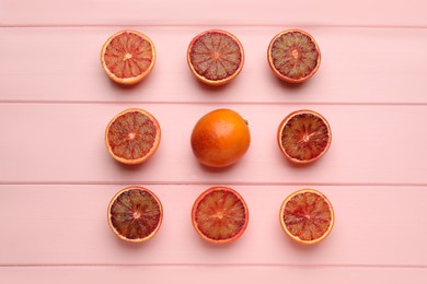Many ripe sicilian oranges on pink wooden table, flat lay