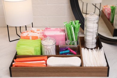 Wooden organizer with different feminine hygiene products on table