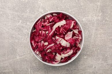 Cut radicchio in bowl on grey table, top view